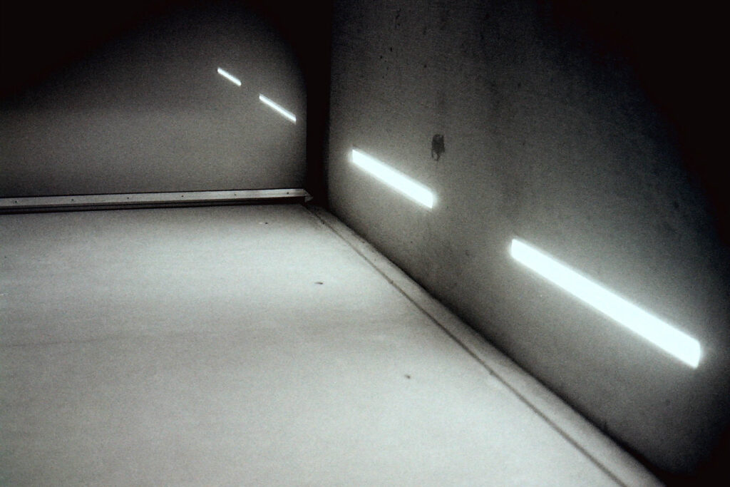 coin de bâtiment avec néons et leurs reflets étranges dans la nuit en noir et blanc