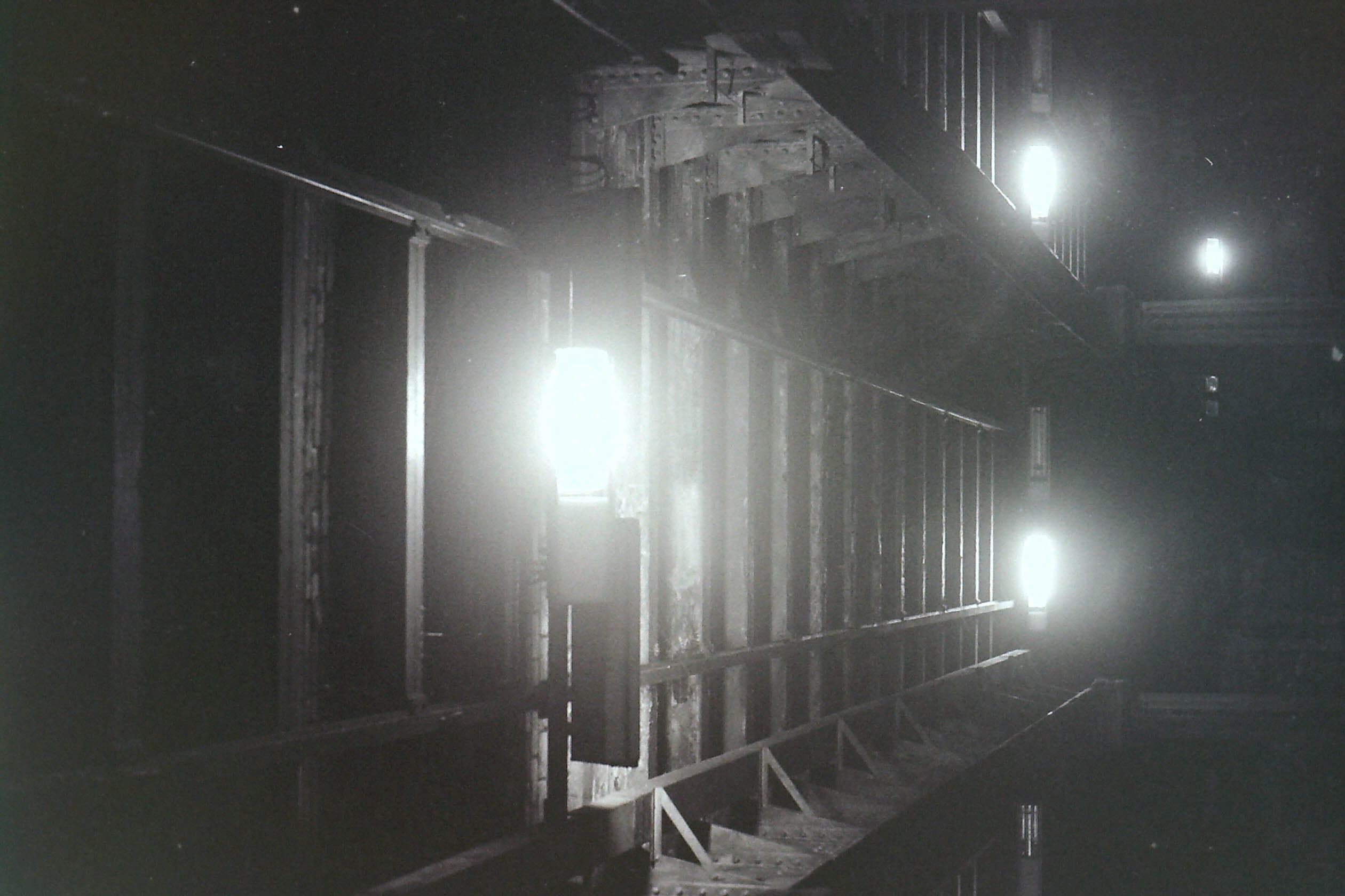 mur de vaisseau spatial avec structure métallique et briques éclairé par des spotlights dans la nuit en noir et blanc