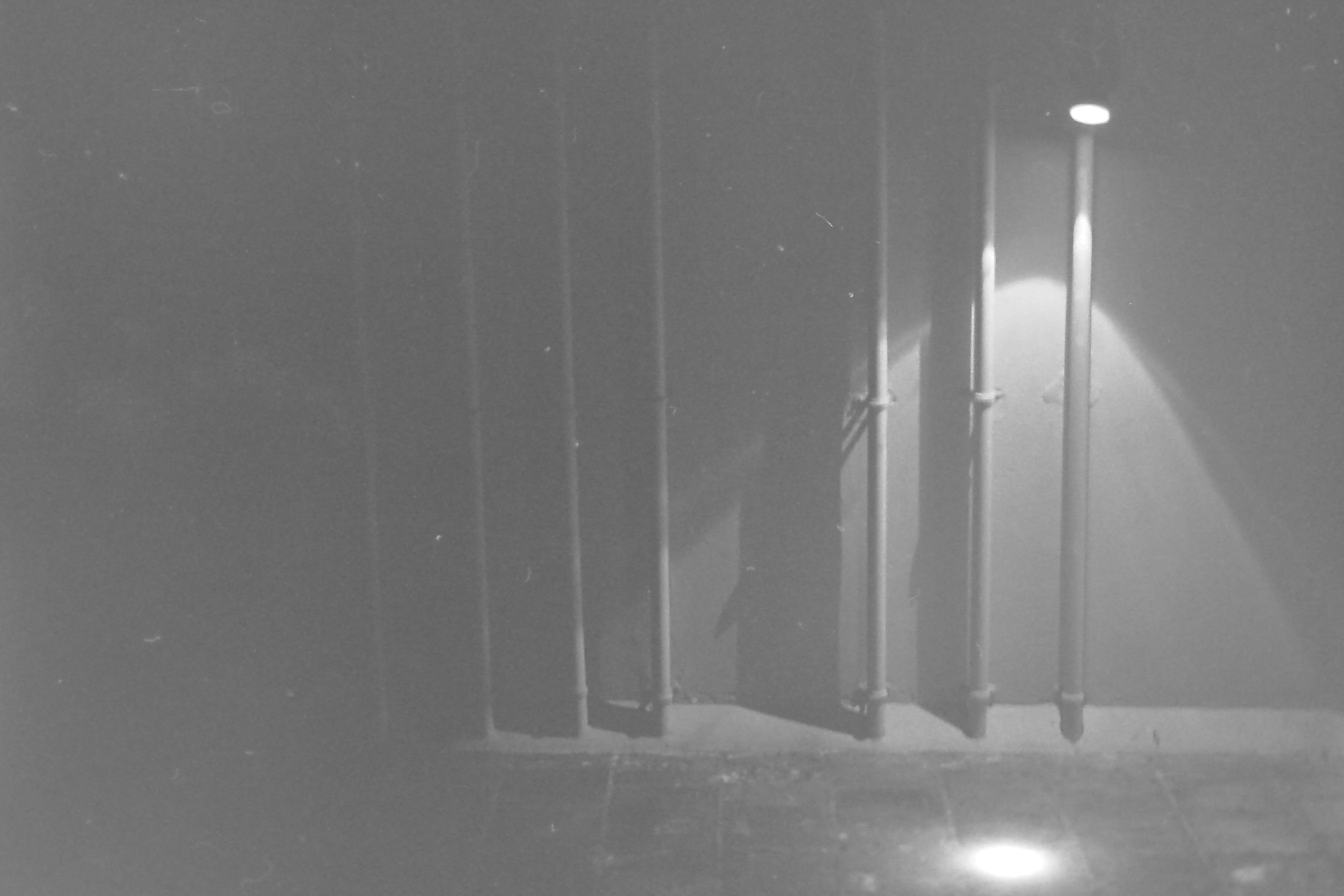 tuyaux de canalisation verticaux éclairés par un spotlight dans la nuit de pondichéry inde en noir et blanc