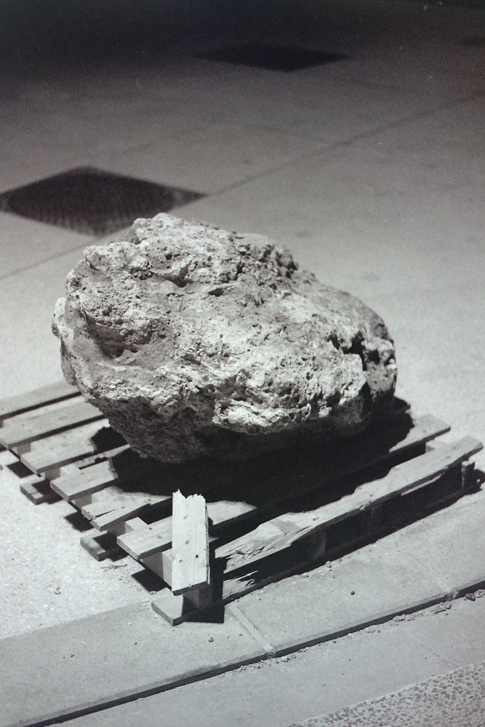 rocher sur palette abîmée posée au sol dans la nuit